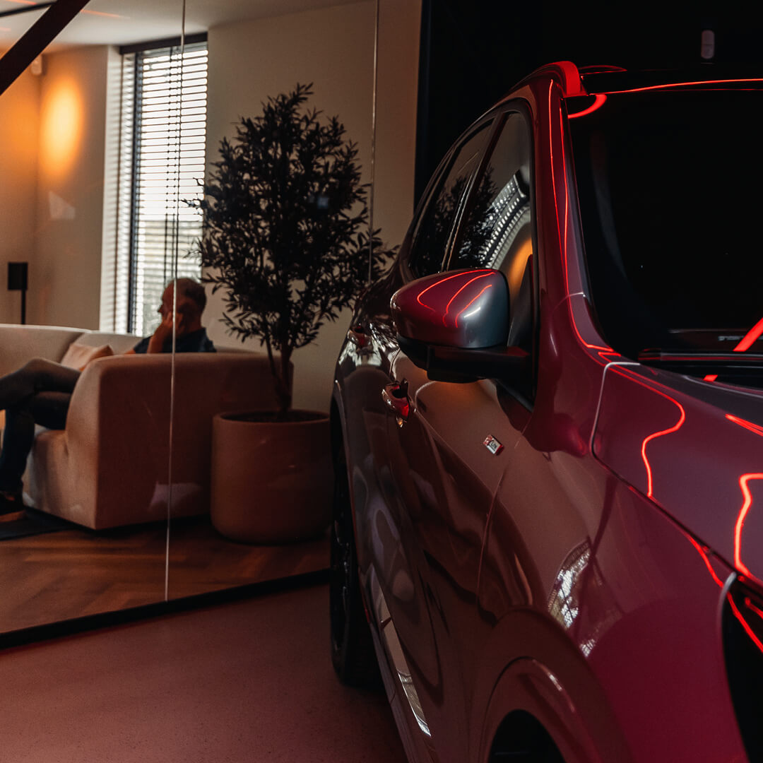 Medewerker aan het bellen op kantoor met auto op de voorgrond