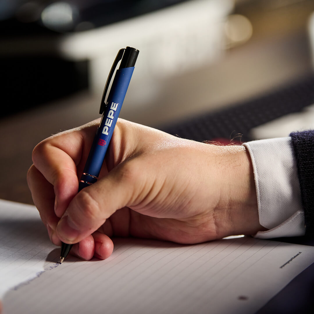 Close-up van collega die met een PEPE pen iets opschrijft, passend bij kostenbesparing