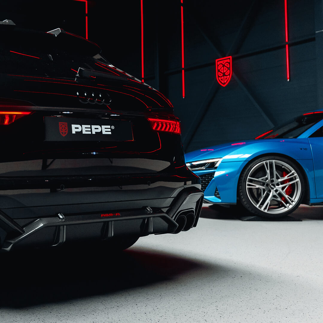 Achteraanzicht van een zwarte en blauwe Audi in een luxe loods